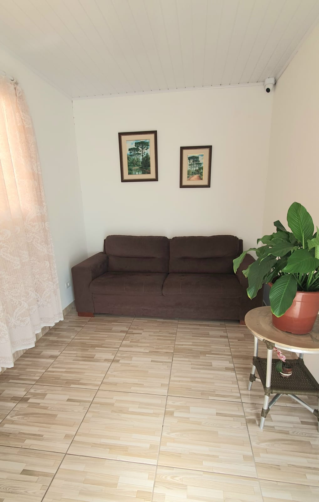 Sala de convivência aconchegante com sofá e quadros
