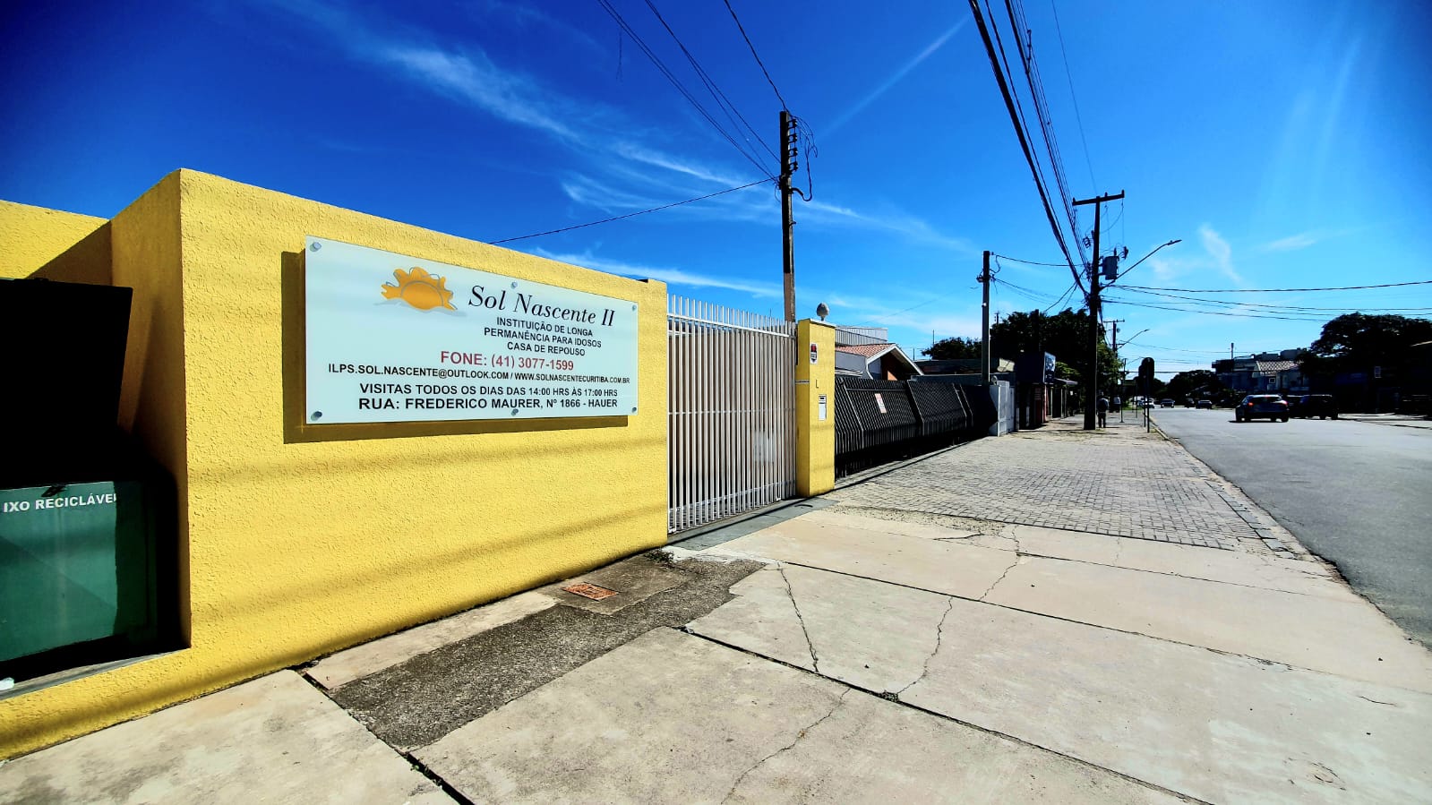 Fachada amarela da Casa Sol Nascente com placa de identificação