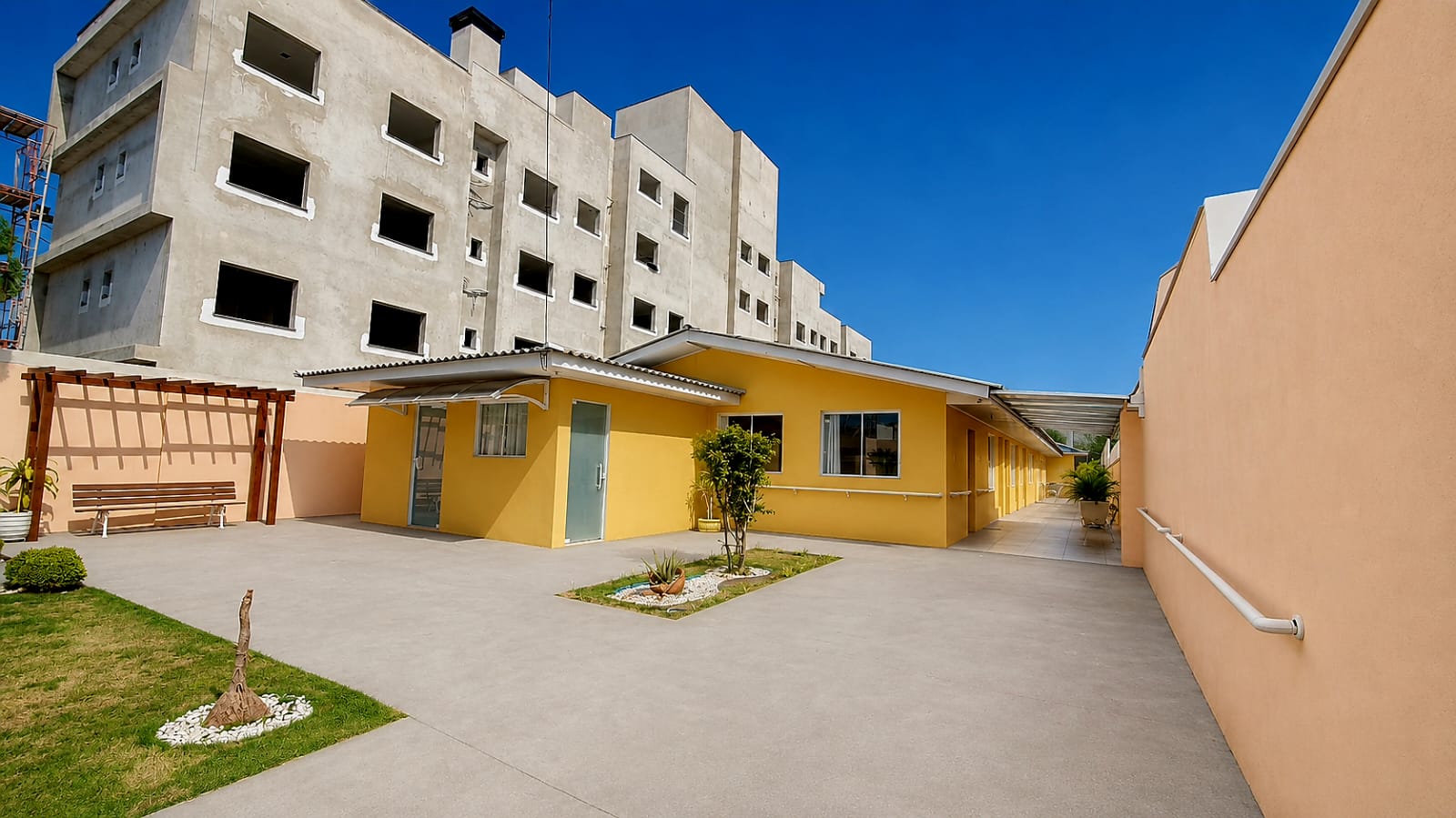 Pátio externo com jardim, bancos e área de convivência ao ar livre